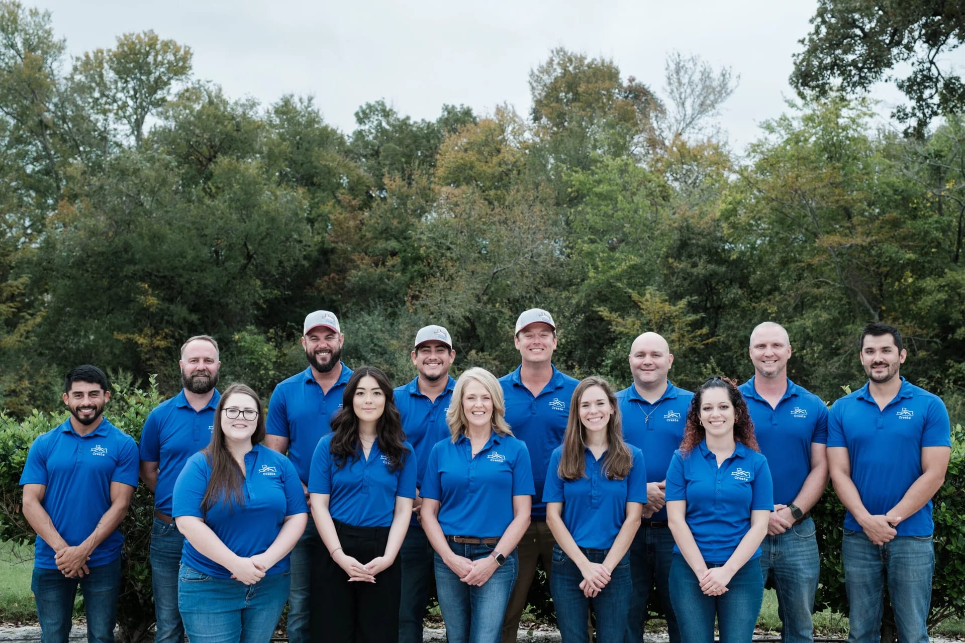 Create team gathered outdoors in blue shirts, photographed in 2024