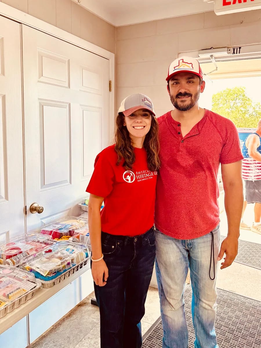 Two volunteers wearing red shirts at a community event