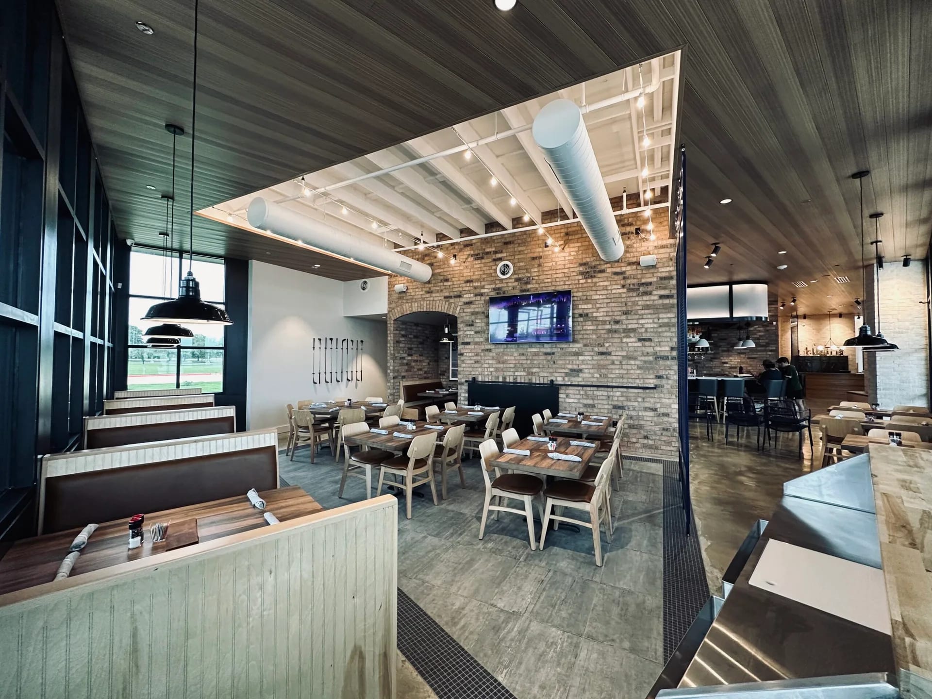 Varsity Grillhouse interior with warm wood and exposed structure
